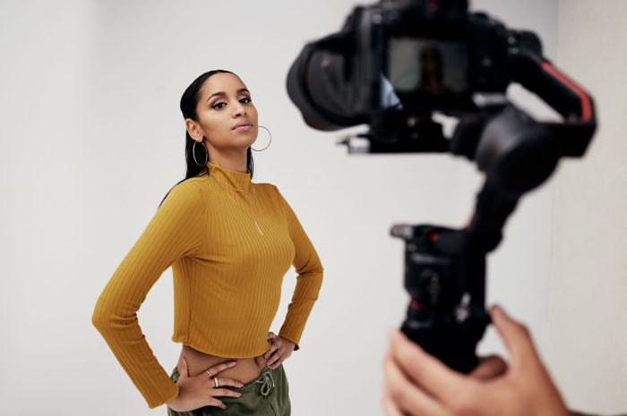 Photography, woman and cameraman or photographer with fashion model in studio for creative, capture.